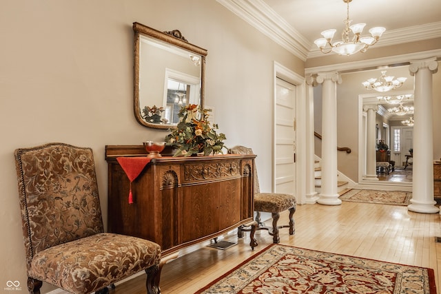 corridor featuring crown molding, hardwood / wood-style flooring, a notable chandelier, and decorative columns