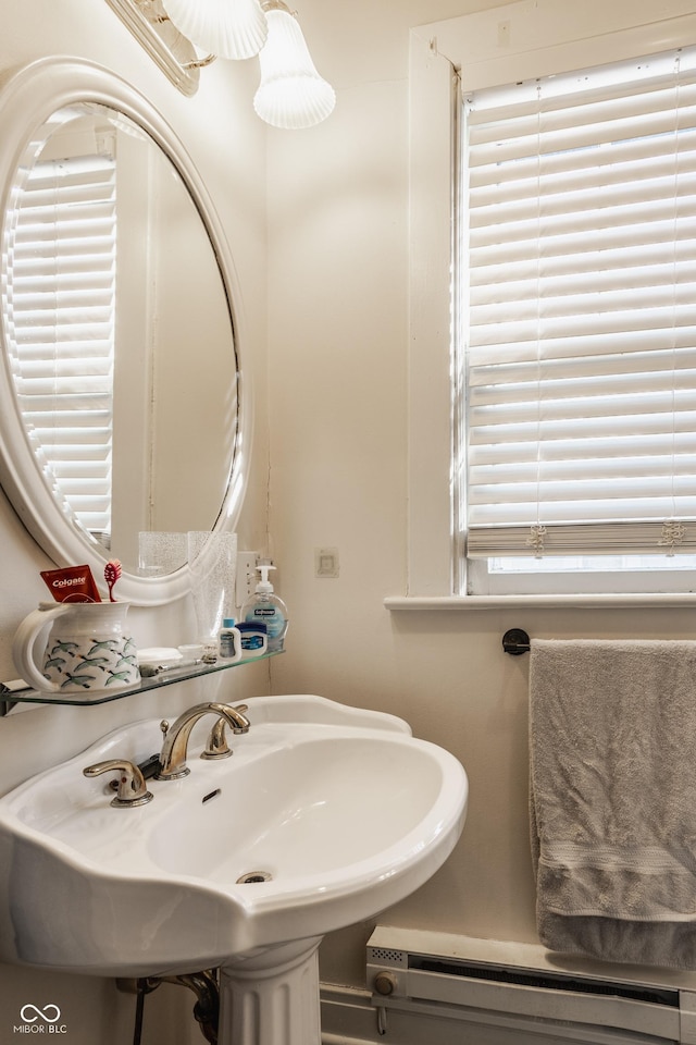 bathroom with a baseboard heating unit and a sink