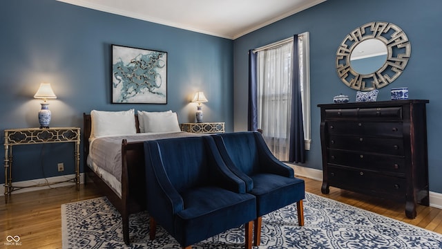 bedroom with baseboards, wood finished floors, and ornamental molding