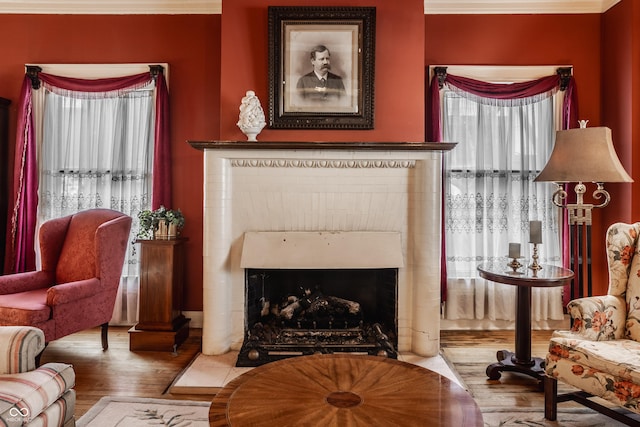 living area with a fireplace with flush hearth and wood finished floors