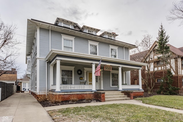 traditional style home with a porch and a front lawn