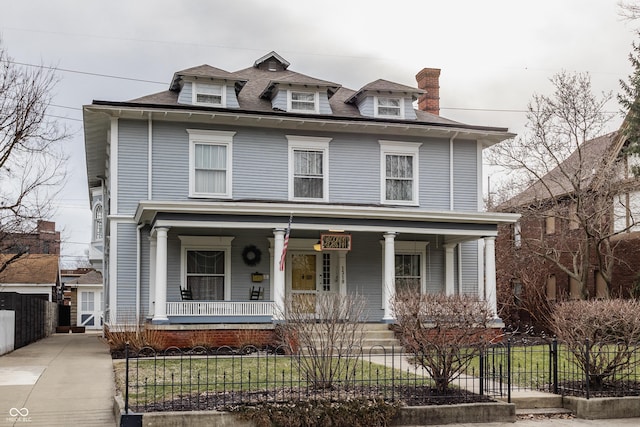 american foursquare style home with a porch and a fenced front yard