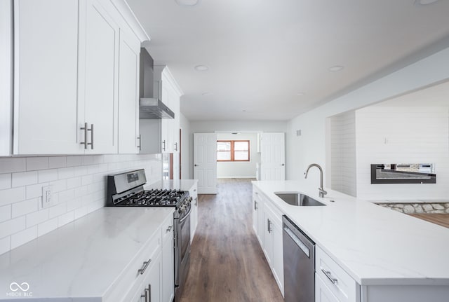 kitchen with a kitchen island with sink, appliances with stainless steel finishes, sink, and white cabinets