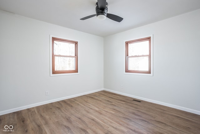 unfurnished room featuring hardwood / wood-style flooring, a wealth of natural light, and ceiling fan