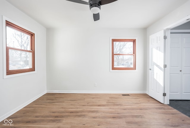 empty room with ceiling fan, light hardwood / wood-style flooring, and a wealth of natural light