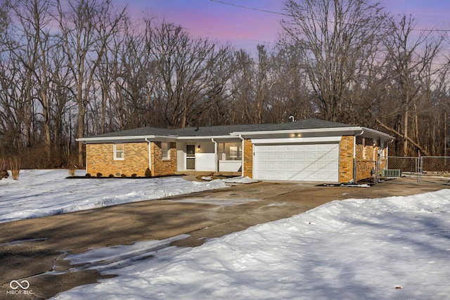 view of front of property featuring a garage and central AC