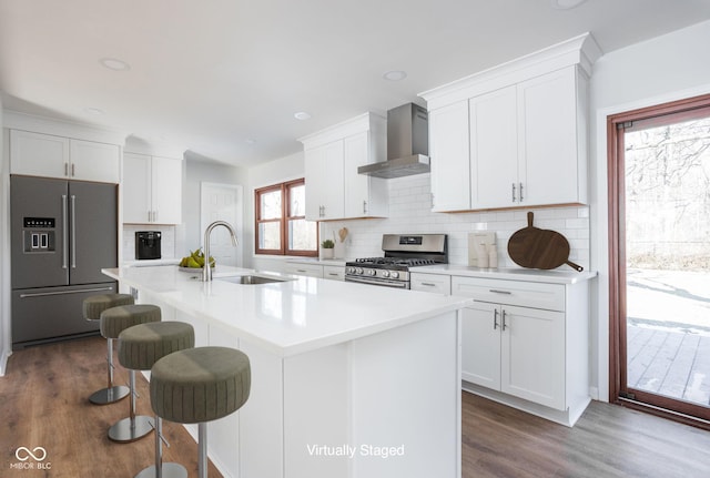 kitchen featuring sink, white cabinets, wall chimney exhaust hood, and appliances with stainless steel finishes