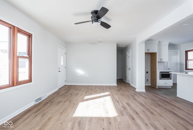 unfurnished living room with ceiling fan and light hardwood / wood-style flooring