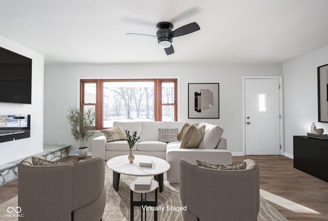 living room with a large fireplace, hardwood / wood-style floors, and ceiling fan