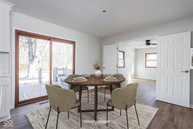 dining area with dark wood-type flooring and ceiling fan