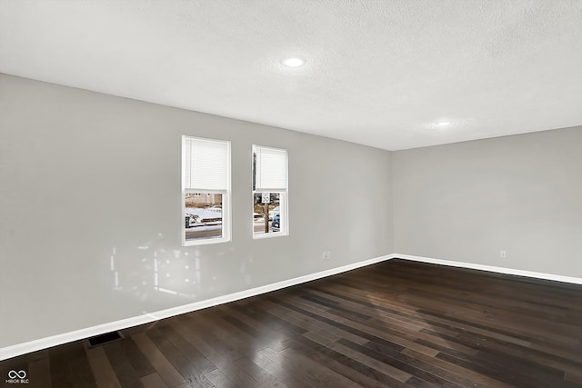 empty room featuring hardwood / wood-style flooring and a textured ceiling