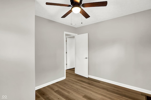 unfurnished room featuring ceiling fan and dark wood-type flooring