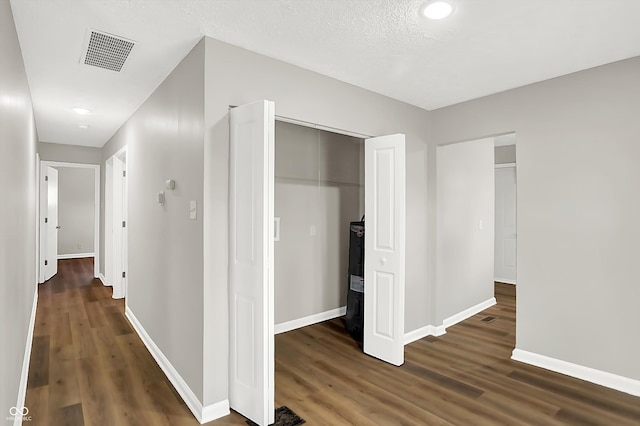 corridor with dark hardwood / wood-style flooring