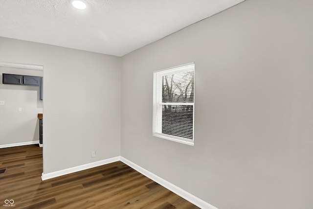 unfurnished room with dark hardwood / wood-style floors