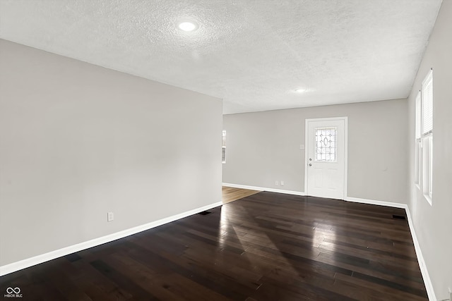 unfurnished room with hardwood / wood-style flooring and a textured ceiling