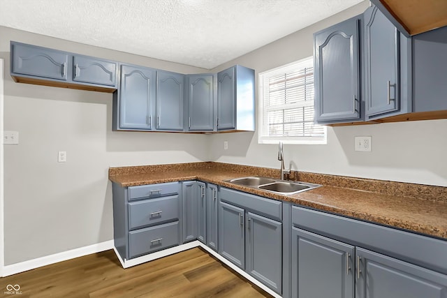 kitchen featuring sink, dark wood-type flooring, and a textured ceiling