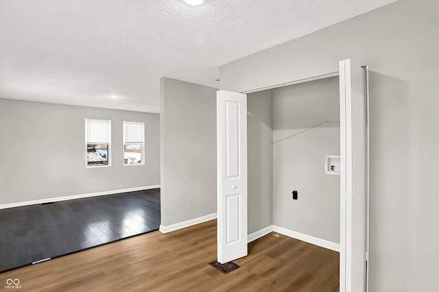 washroom featuring hardwood / wood-style floors, a textured ceiling, and washer hookup