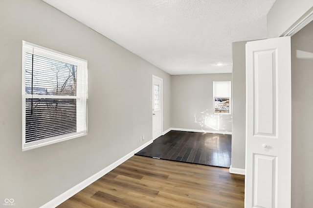 unfurnished room featuring hardwood / wood-style floors and a textured ceiling