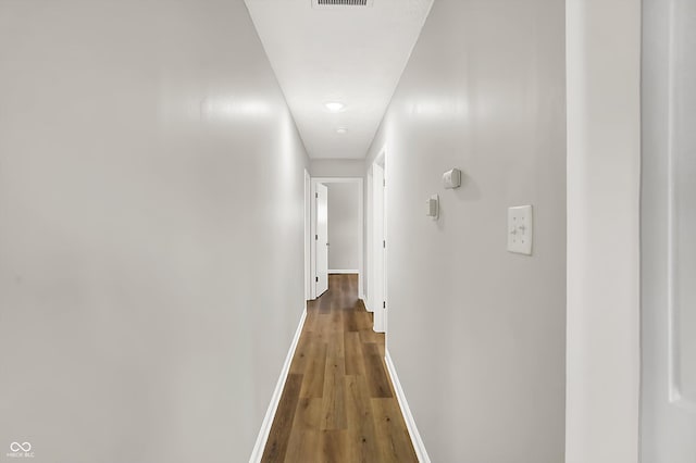 corridor with hardwood / wood-style flooring