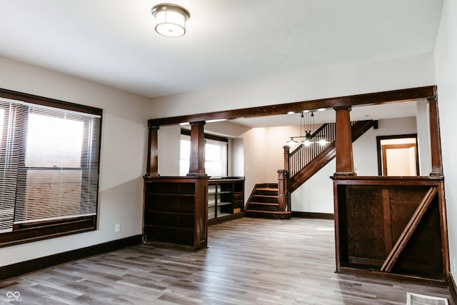 spare room featuring hardwood / wood-style floors and ornate columns