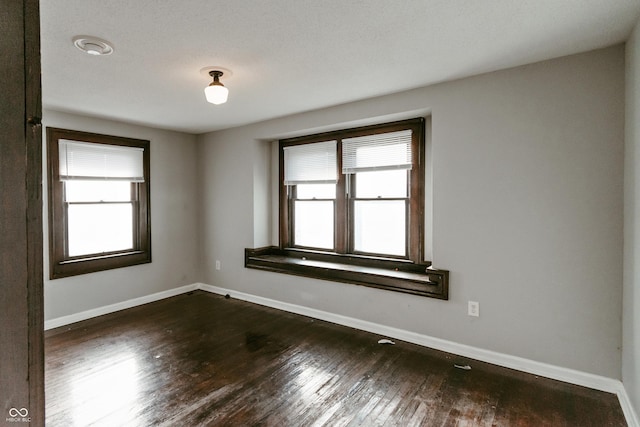 empty room with dark hardwood / wood-style flooring