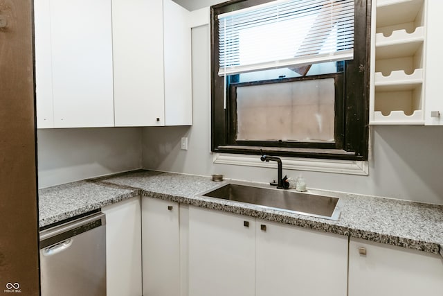 kitchen with white cabinetry, sink, light stone countertops, and dishwasher