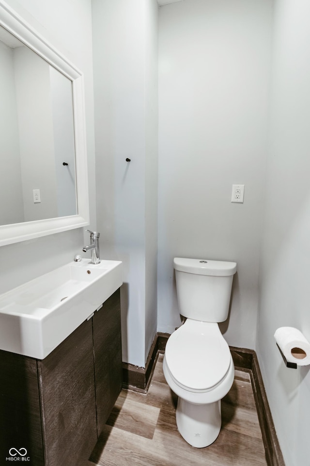 bathroom featuring vanity, hardwood / wood-style floors, and toilet