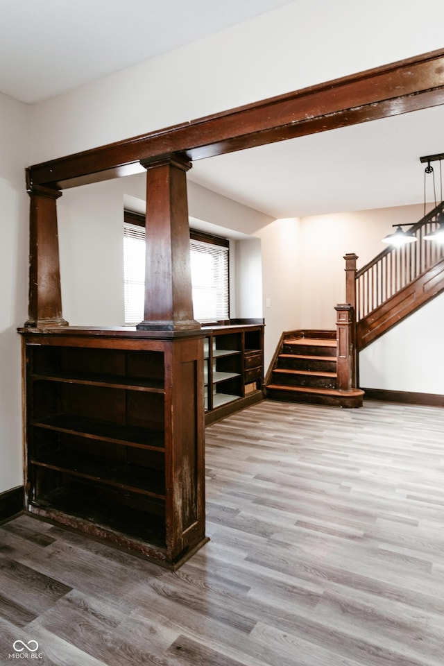 bar featuring hardwood / wood-style floors and ornate columns