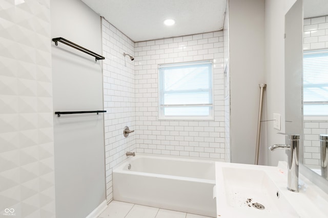 bathroom with tiled shower / bath combo, a wealth of natural light, tile patterned floors, and a textured ceiling