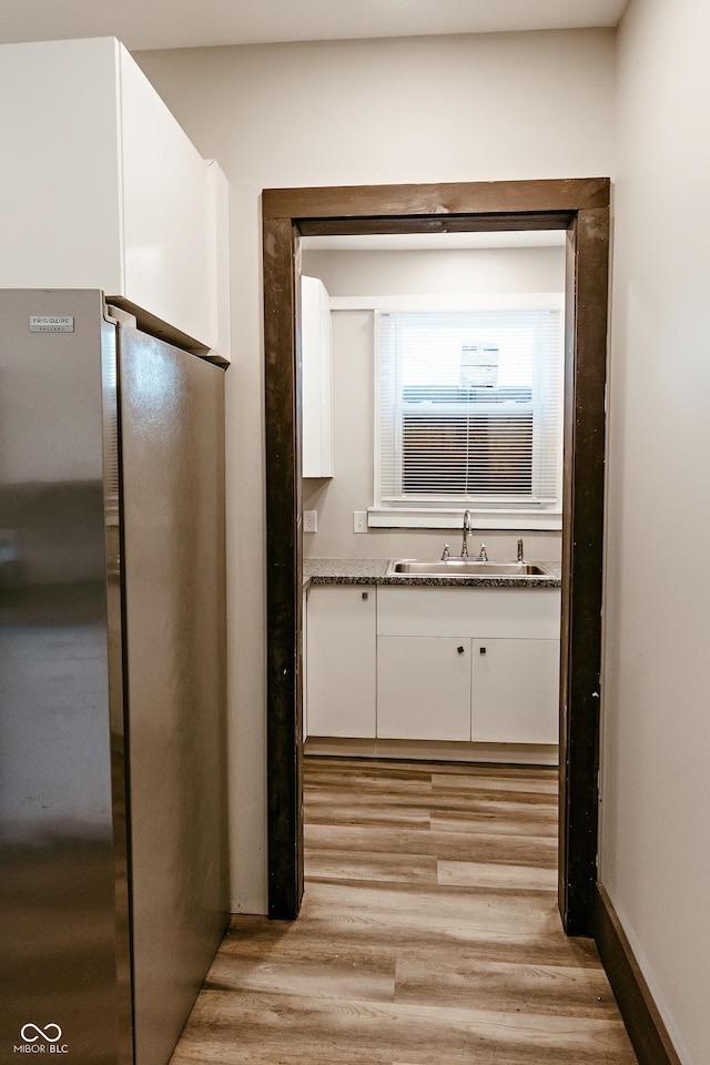 hallway with sink and light hardwood / wood-style flooring