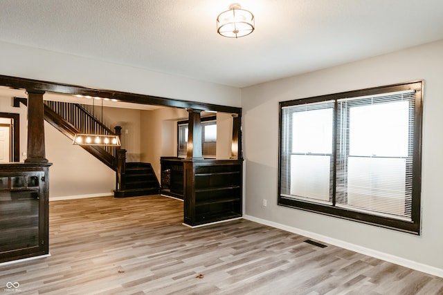 interior space with a textured ceiling and light hardwood / wood-style flooring