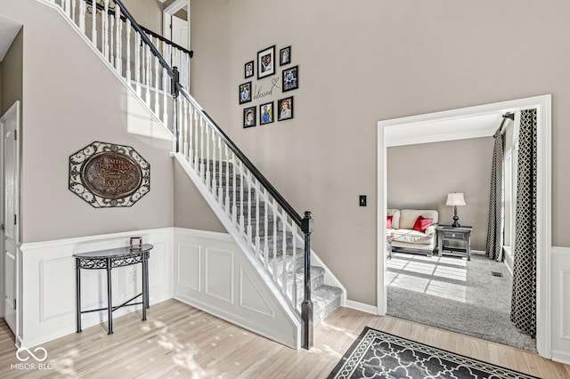 stairway with hardwood / wood-style flooring and a high ceiling