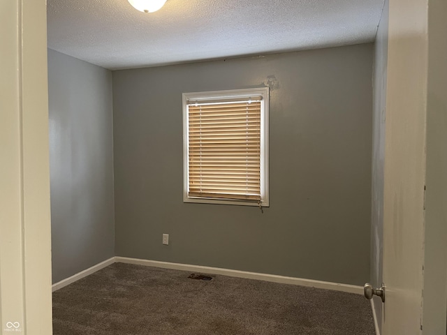 carpeted spare room featuring a textured ceiling