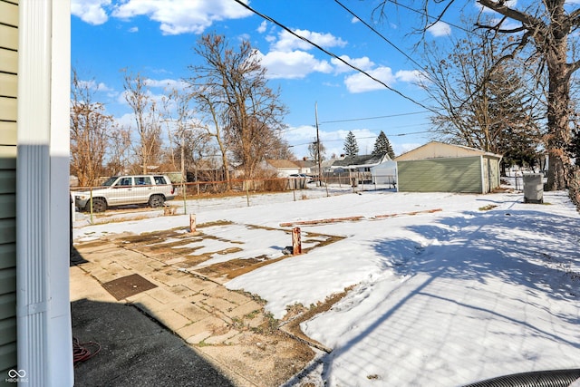 snowy yard with an outbuilding and a garage