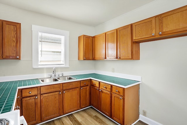 kitchen featuring sink, tile countertops, and light hardwood / wood-style floors