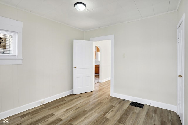 unfurnished bedroom with crown molding and light hardwood / wood-style floors