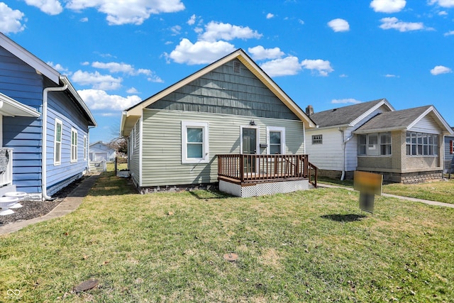 rear view of house featuring a lawn and a deck