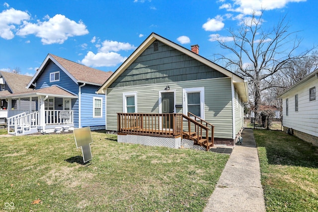 rear view of property with a yard and a chimney