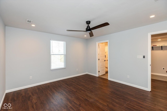 unfurnished bedroom featuring ceiling fan, a spacious closet, dark hardwood / wood-style flooring, and ensuite bath