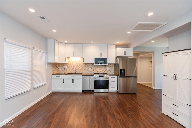 kitchen featuring decorative backsplash, sink, white cabinetry, and stainless steel appliances