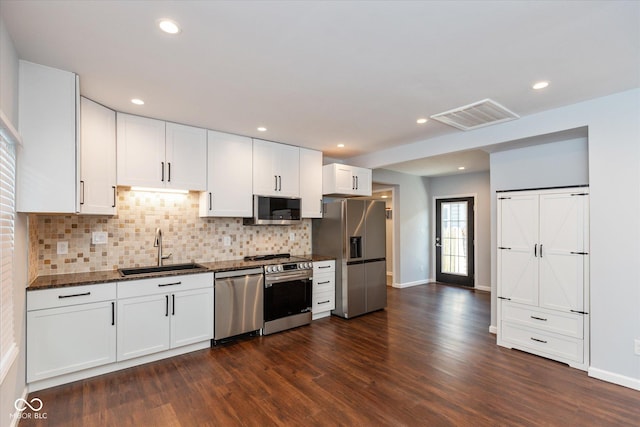 kitchen featuring sink, white cabinets, dark stone countertops, and stainless steel appliances