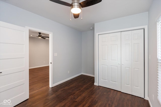 unfurnished bedroom with ceiling fan, dark hardwood / wood-style floors, and a closet