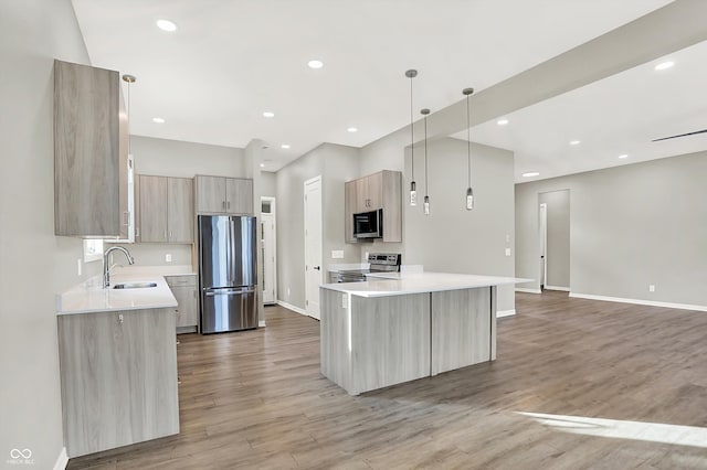 kitchen with sink, a center island, hanging light fixtures, light brown cabinets, and stainless steel appliances