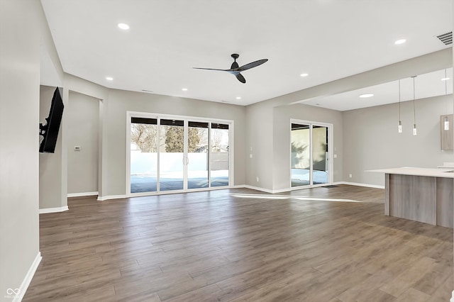 unfurnished living room with hardwood / wood-style flooring and ceiling fan