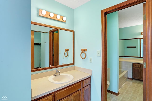 bathroom with vanity, toilet, a tub, and a textured ceiling