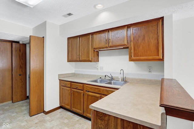 kitchen with sink and a textured ceiling