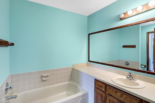 bathroom with vanity, a washtub, and a textured ceiling