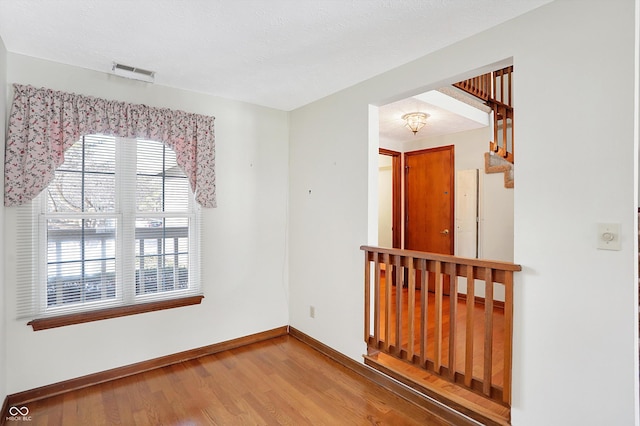 unfurnished room with wood-type flooring