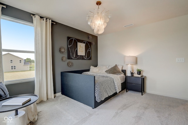 bedroom with a notable chandelier and light colored carpet