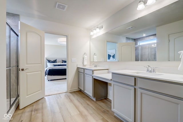 bathroom featuring hardwood / wood-style floors, an enclosed shower, and vanity